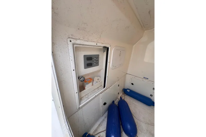 Slide: The Image of Interior of 2004 Pursuit 2670 Cuddy Console with storage compartments and blue fenders. - 36