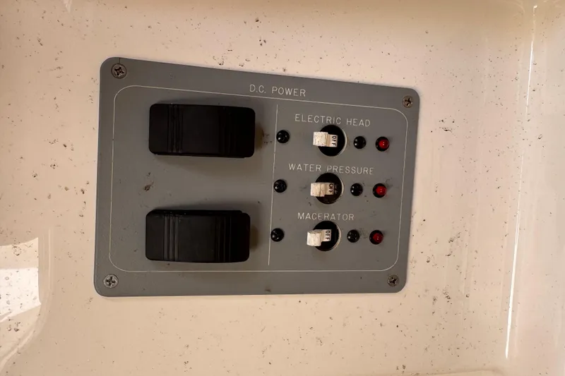Slide: The Image of Control panel on a 2004 Pursuit 2670 Cuddy Console boat, featuring switches and indicators. - 37