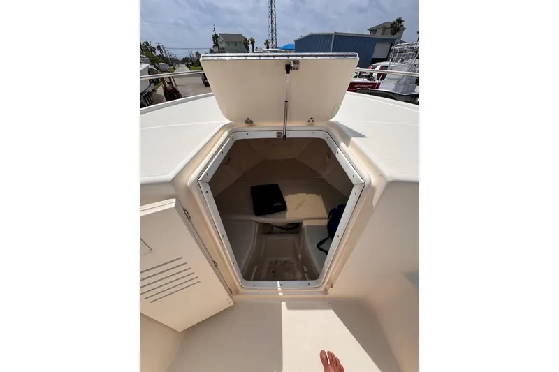 Slide: The Image of 2004 Pursuit 2670 Cuddy Console boat interior with open hatch, docked outdoors. - 44