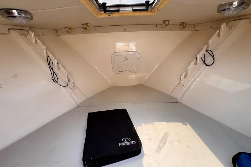 Slide: The Image of Interior of 2004 Pursuit 2670 Cuddy Console boat, featuring storage and lighting. - 45