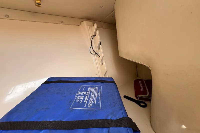 Slide: The Image of Interior of 2004 Pursuit 2670 Cuddy Console with blue storage bag and Raymarine equipment. - 48