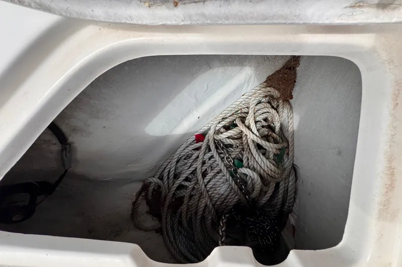 Slide: The Image of Coiled rope in storage compartment of 2004 Pursuit 2670 Cuddy Console boat. - 51