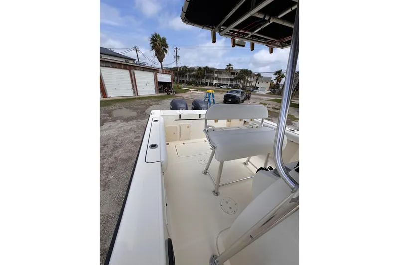 Slide: The Image of 2004 Pursuit 2670 Cuddy Console boat interior with seating and console, parked outdoors. - 52