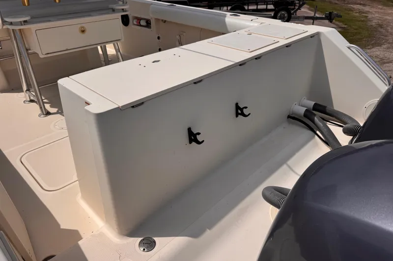 Slide: The Image of 2004 Pursuit 2670 Cuddy Console boat interior with storage compartments and seating area. - 6
