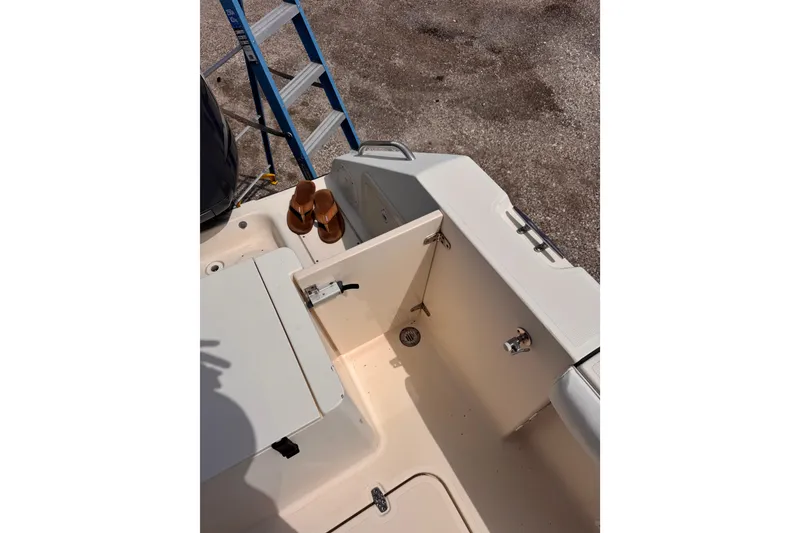 Slide: The Image of 2004 Pursuit 2670 Cuddy Console boat interior with storage compartment and ladder. - 8
