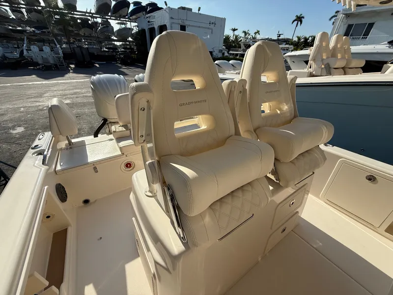 Slide: The Image of Two luxurious, cushioned seats on a boat, surrounded by a sunny marina. - 15
