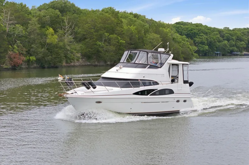 The Image of 2005 Carver 39 Motor Yacht cruising on a scenic river with lush green trees. - 0