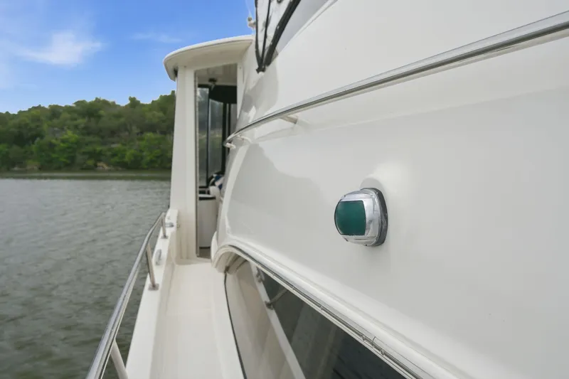 Slide: The Image of 2005 Carver 39 Motor Yacht side view on calm water, showcasing sleek design. - 10