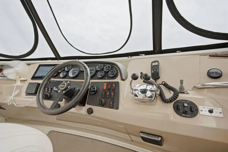 Slide: The Image of 2005 Carver 39 Motor Yacht helm with steering wheel, gauges, and controls. - 18
