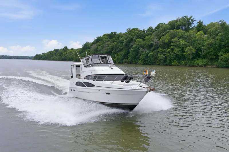 Slide: The Image of 2005 Carver 39 Motor Yacht cruising on a scenic river with lush green trees. - 3