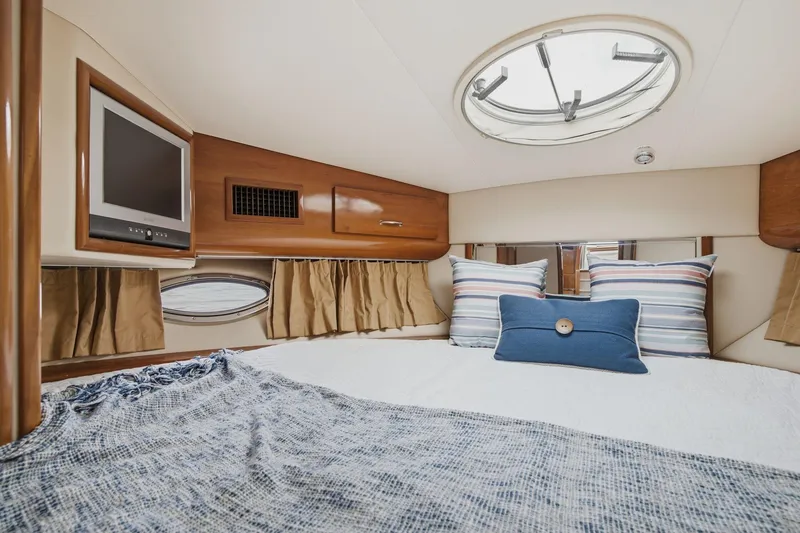 Slide: The Image of Luxurious 2005 Carver 39 Motor Yacht bedroom with cozy bedding and a mounted TV. - 34
