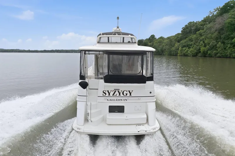 Slide: The Image of 2005 Carver 39 Motor Yacht cruising on a serene river with lush green surroundings. - 6