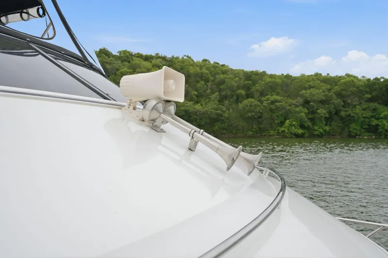 Slide: The Image of 2005 Carver 39 Motor Yacht horn and speaker on deck, with scenic lake backdrop. - 9