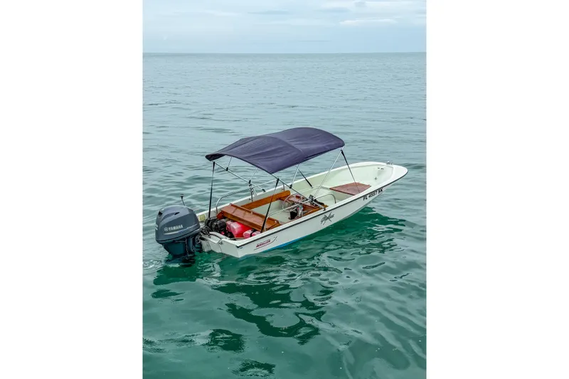 Slide: The Image of 1983 Boston Whaler 15 boat with Yamaha motor on calm sea. - 3