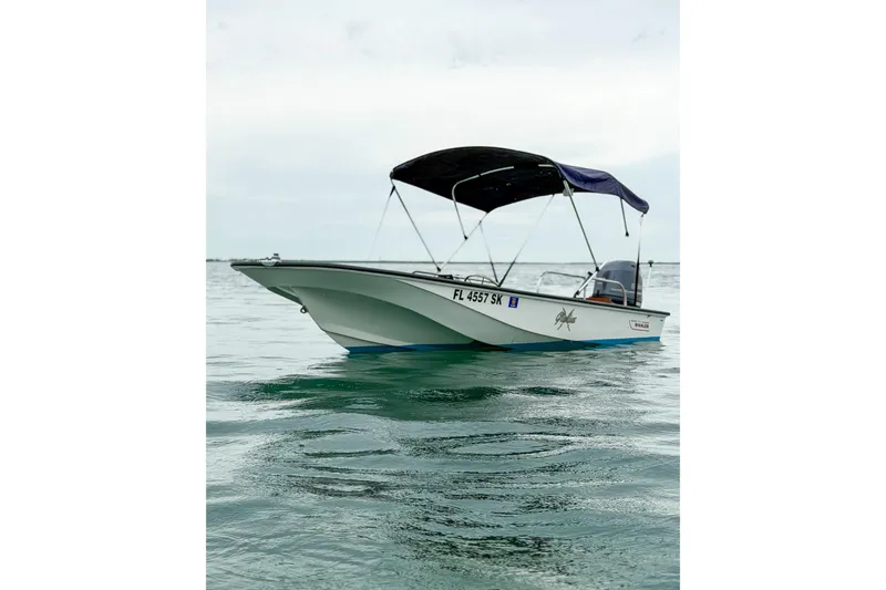 Slide: The Image of 1983 Boston Whaler 15 boat with canopy on calm water. - 4