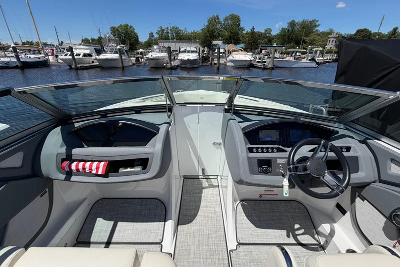 Slide: The Image of 2020 Cobalt R3 boat cockpit with steering wheel, dashboard, and marina view. - 10
