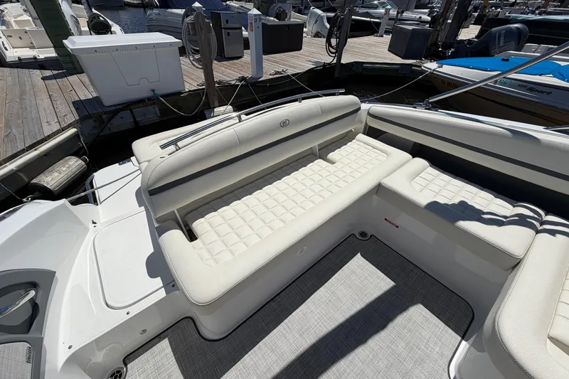 Slide: The Image of 2020 Cobalt R3 boat interior with white cushioned seating at a marina. - 18