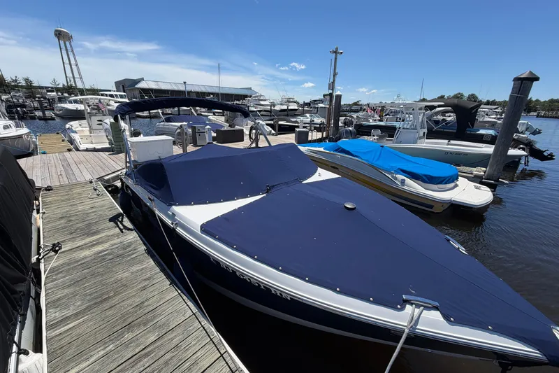 Slide: The Image of 2020 Cobalt R3 boat docked at marina with blue cover. - 24
