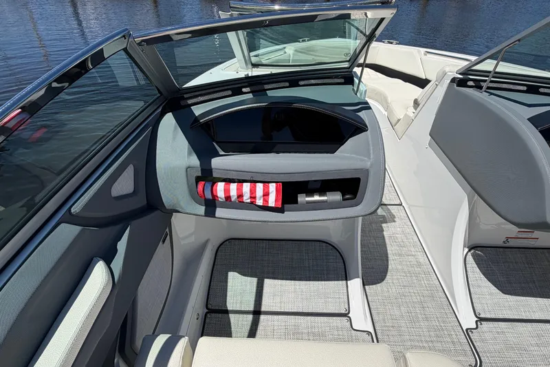 Slide: The Image of 2020 Cobalt R3 boat interior with open windshield and striped towel, docked on water. - 9