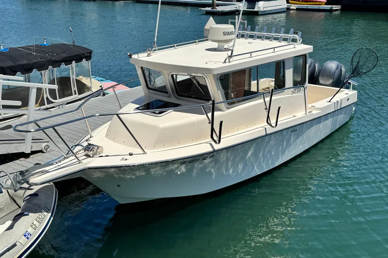 The Image of 2016 Defiance San Juan 250 boat docked in marina, featuring dual engines and fishing equipment. - 0