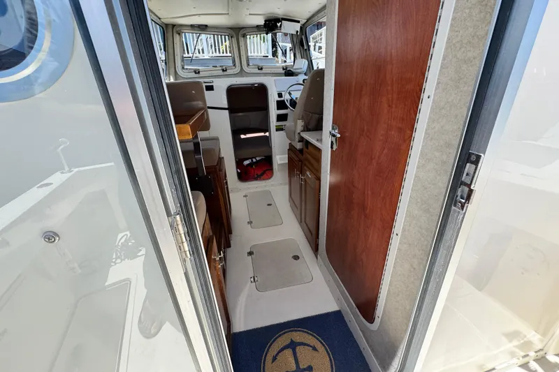 Slide: The Image of Interior view of 2016 Defiance San Juan 250 boat, featuring cabin and helm area. - 13