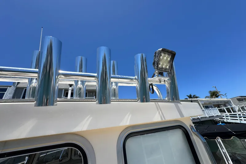 Slide: The Image of 2016 Defiance San Juan 250 boat with rod holders and spotlight against clear blue sky. - 14