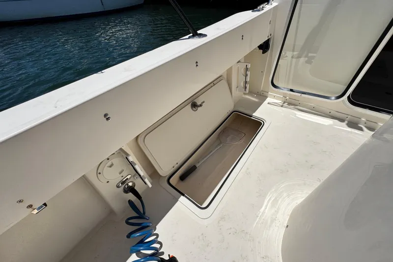 Slide: The Image of 2016 Defiance San Juan 250 boat interior with storage compartment and water hose. - 15