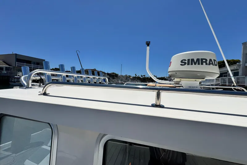 Slide: The Image of 2016 Defiance San Juan 250 boat with Simrad radar on roof, docked under clear blue sky. - 21