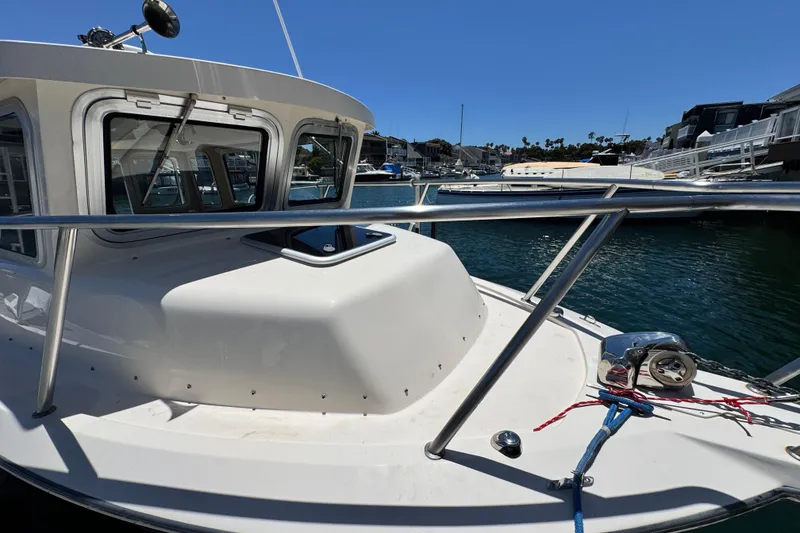 Slide: The Image of 2016 Defiance San Juan 250 boat docked in marina, featuring sleek design and sturdy railings. - 22