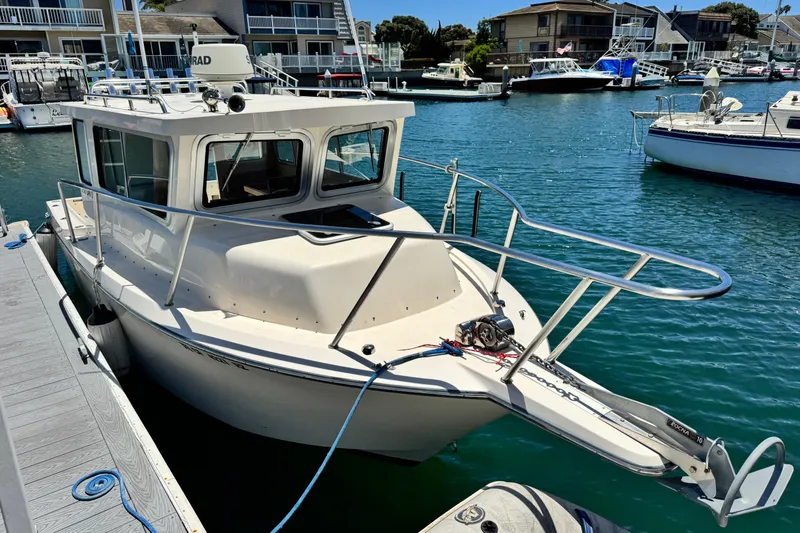 Slide: The Image of 2016 Defiance San Juan 250 boat docked in a marina, surrounded by water and other boats. - 24
