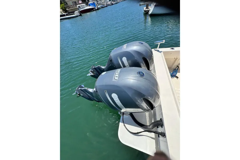 Slide: The Image of Twin Yamaha outboard motors on a 2016 Defiance San Juan 250 boat in a marina. - 25