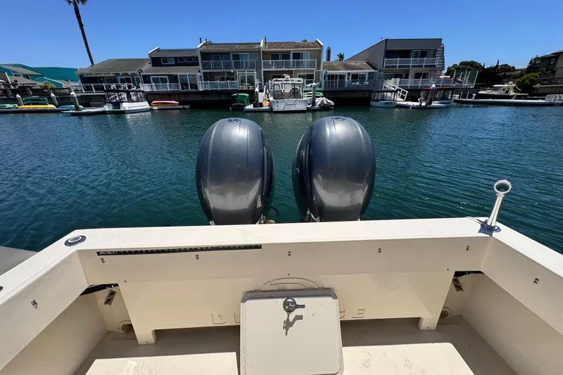 Slide: The Image of 2016 Defiance San Juan 250 boat with dual outboard motors docked in a marina. - 31