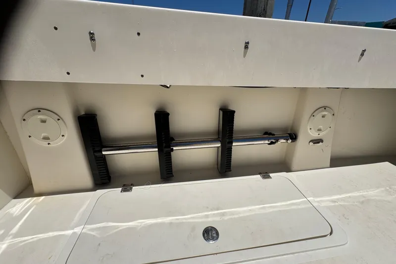 Slide: The Image of 2016 Defiance San Juan 250 boat interior storage compartment with rod holders and hatch. - 33