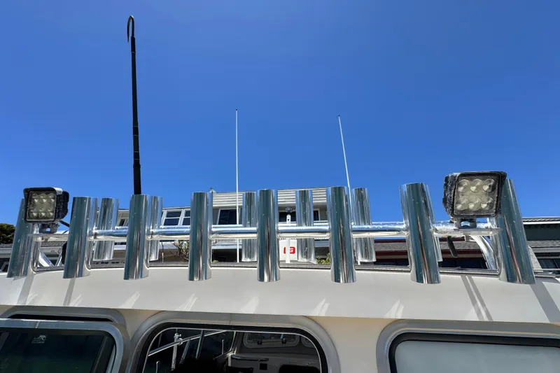 Slide: The Image of 2016 Defiance San Juan 250 boat with rod holders and lights against clear blue sky. - 34