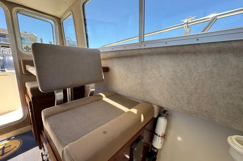 Slide: The Image of Interior of a 2016 Defiance San Juan 250 boat with seating and windows. - 37