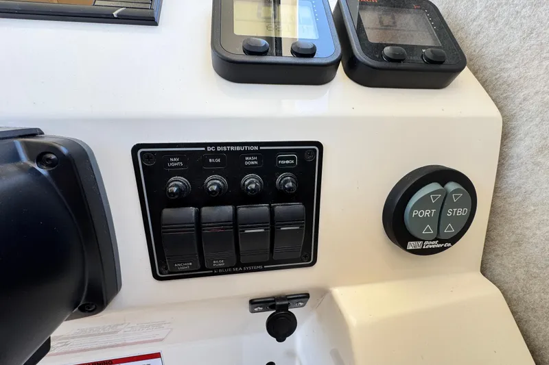 Slide: The Image of Control panel of a 2016 Defiance San Juan 250 boat with switches and gauges. - 43