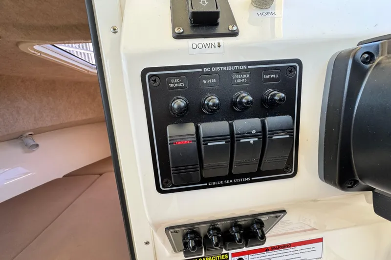 Slide: The Image of Control panel of a 2016 Defiance San Juan 250 boat, featuring DC distribution switches. - 44