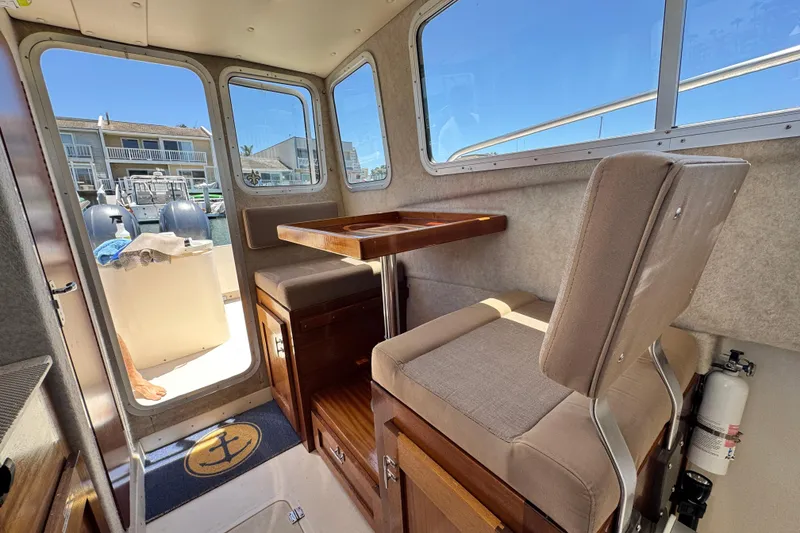 Slide: The Image of Interior of 2016 Defiance San Juan 250 boat with seating and table, dockside view. - 49
