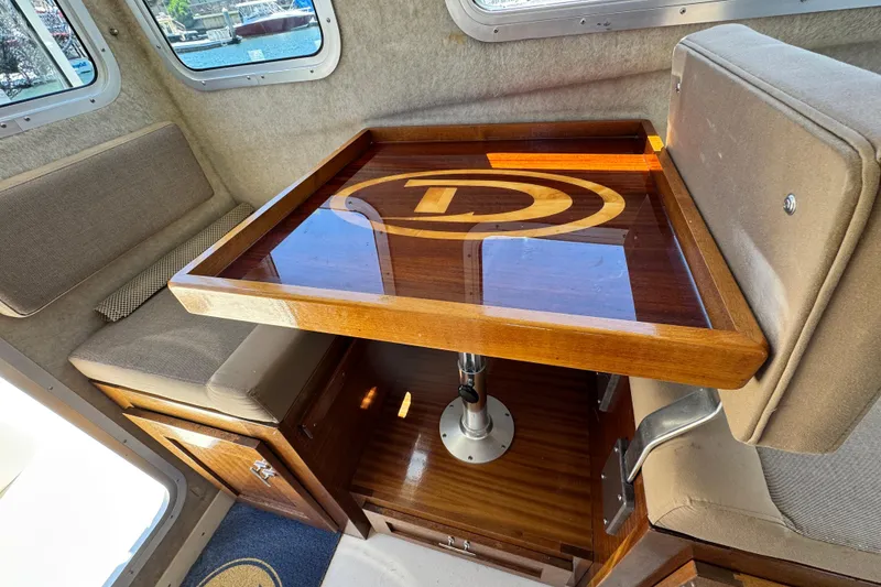 Slide: The Image of Interior of 2016 Defiance San Juan 250 boat with polished wooden table and seating. - 5