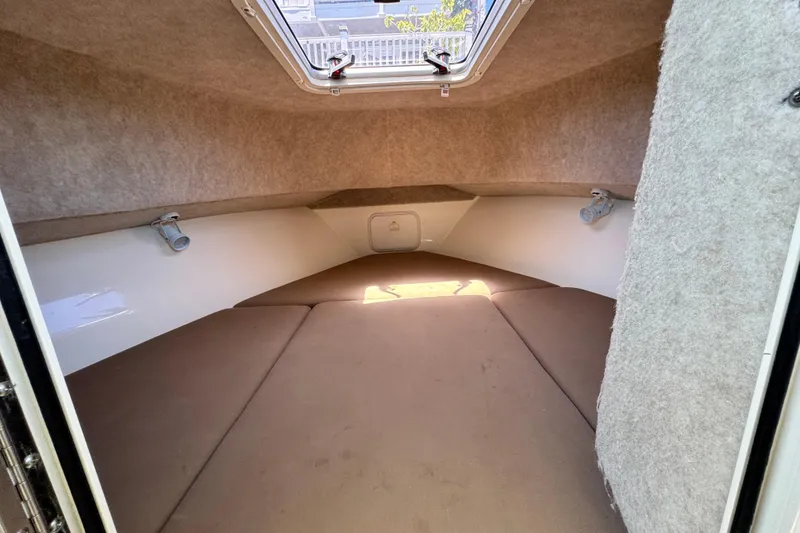Slide: The Image of 2016 Defiance San Juan 250 cabin interior with brown cushions and overhead hatch. - 50