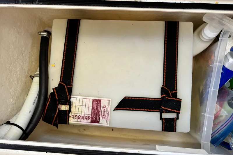 Slide: The Image of Storage compartment in a 2016 Defiance San Juan 250 boat with secured equipment and supplies. - 58