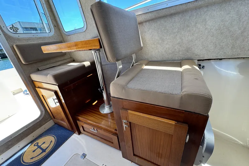Slide: The Image of Interior of 2016 Defiance San Juan 250 boat with cushioned seating and wooden cabinetry. - 6