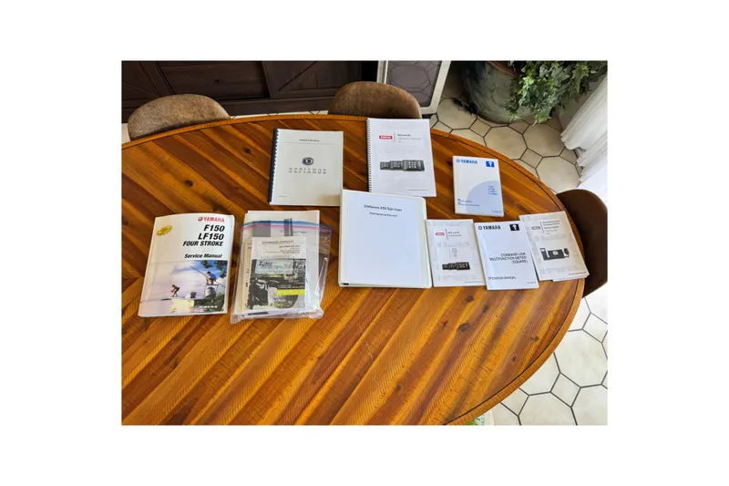 Slide: The Image of Manuals and documents for 2016 Defiance San Juan 250 on a wooden table. - 61