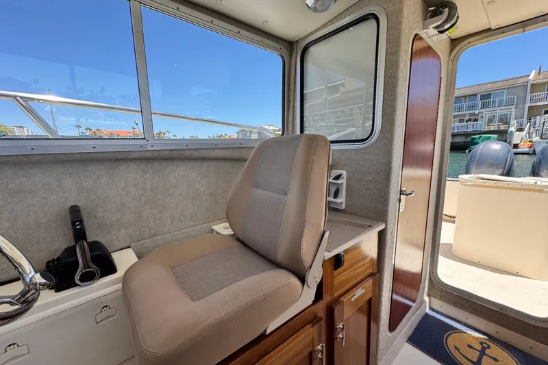 Slide: The Image of Interior of 2016 Defiance San Juan 250 boat with helm seat and window view. - 9