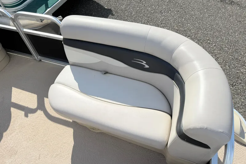 Slide: The Image of 2010 Bennington 20SLi boat seat with white and black upholstery on a sunny day. - 10