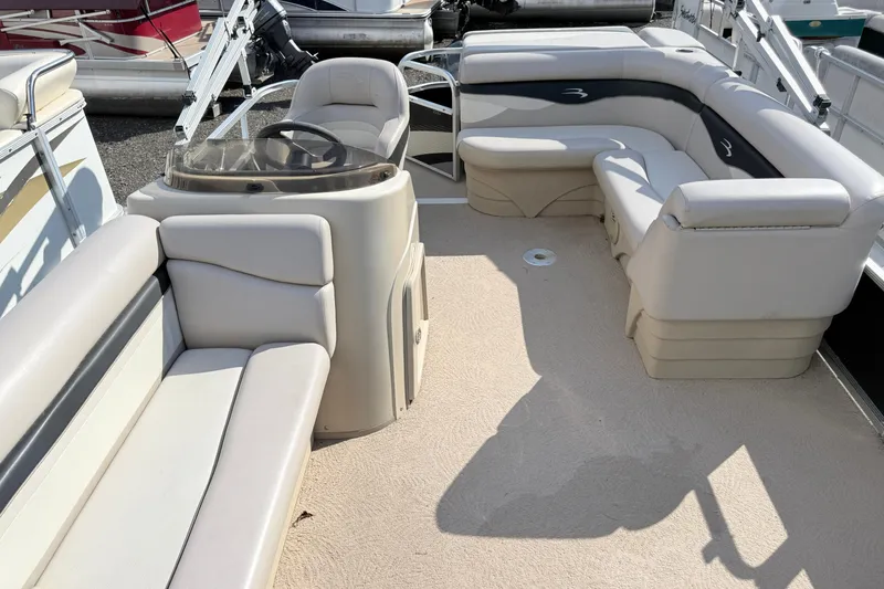 Slide: The Image of 2010 Bennington 20SLi pontoon boat interior with beige seating and steering console. - 11