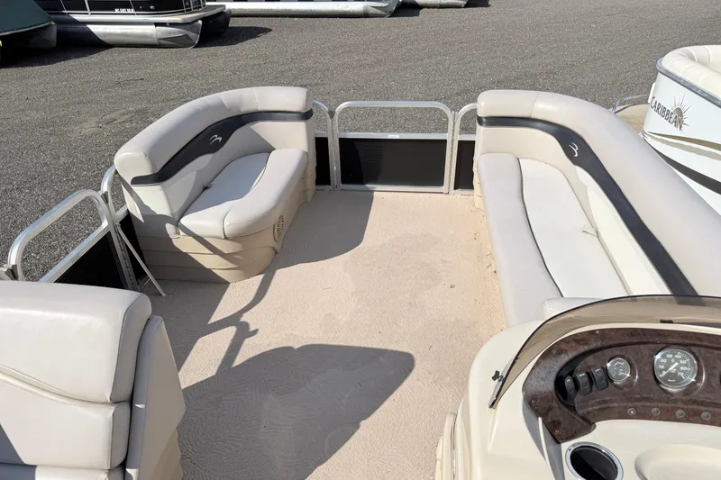 Slide: The Image of Interior of a 2010 Bennington 20SLi pontoon boat with beige seating and dashboard. - 13