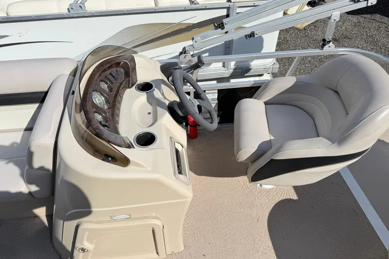 Slide: The Image of Captain's seat and helm of a 2010 Bennington 20SLi pontoon boat, featuring a sleek dashboard. - 6