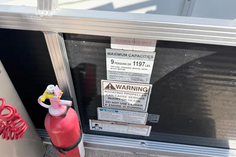 Slide: The Image of Fire extinguisher and safety warnings on 2010 Bennington 20SLi boat. - 8