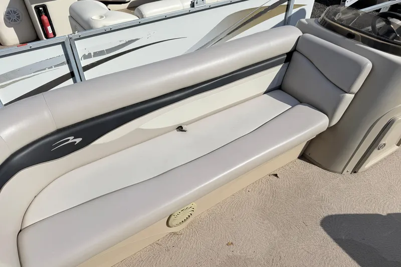 Slide: The Image of 2010 Bennington 20SLi pontoon boat interior with beige seating and console. - 9